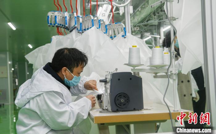工人生產(chǎn)防護(hù)服，保障抗疫物資供應(yīng)。廣安市委宣傳部供圖